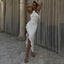 Woman in a white dress standing in front of draped curtains