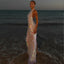 Woman in a sparkling dress standing on a beach at sunset