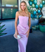 Woman in a pink strapless dress standing in front of a colorful mural.